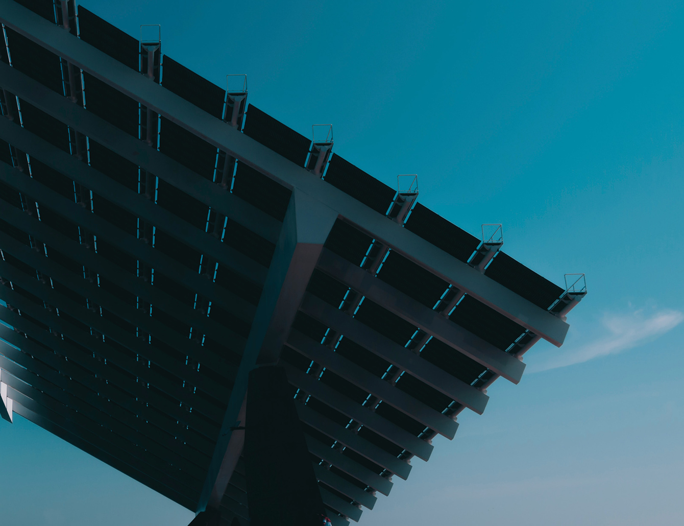 Großes Solarpanel in moderner Architektur vor blauem Himmel, aus ungewöhnlicher Perspektive fotografiert